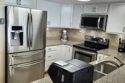 New kitchen in beach condo with smart refrigerator and granite countertops in the remodel.